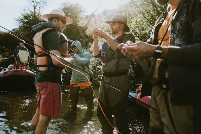 Group fly fishing with guides in a river